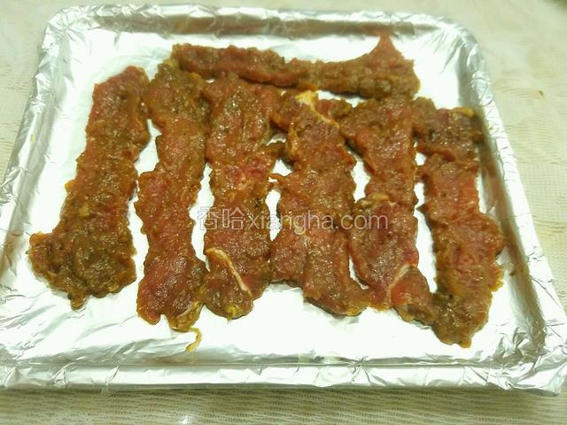 烤盘上铺上锡纸，牛肉平铺放入烤盘。