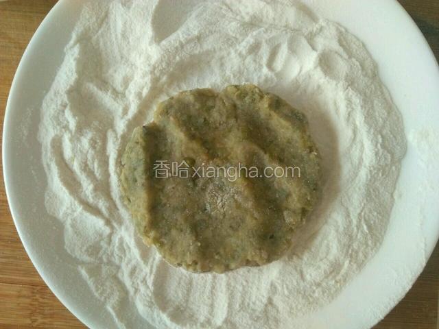 将绿豆团放入炒好的糯米面里压扁