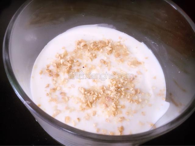碗里倒入酸奶，并撒上捣碎的花生仁
