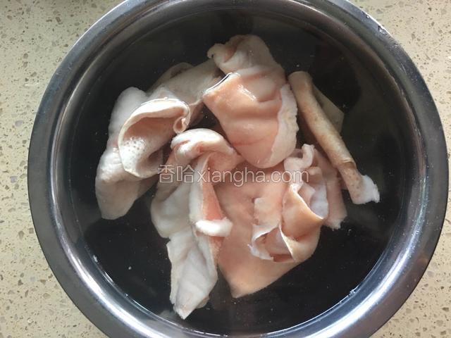 冻猪皮从冰箱里取出，浸泡一会儿，猪皮泡软后，清洗几遍。