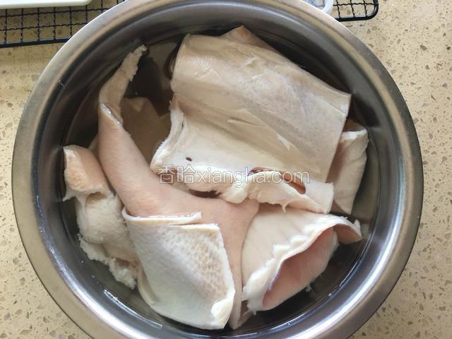 清洗干净的猪皮，在清水里浸泡两个小时。有利于下一步的刮油，浸泡的肉皮不会那么生硬，容易操作。