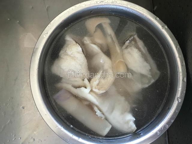 煮过的猪皮捞出放热水盆里。清洗两三遍。