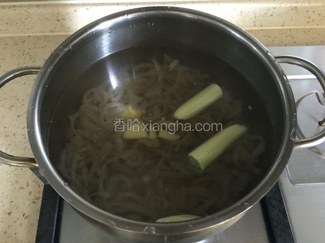 猪皮凉水入锅，水量是猪皮量的3倍，放入葱和姜。