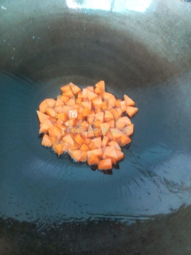 接着再倒入油，下胡萝卜丁翻炒