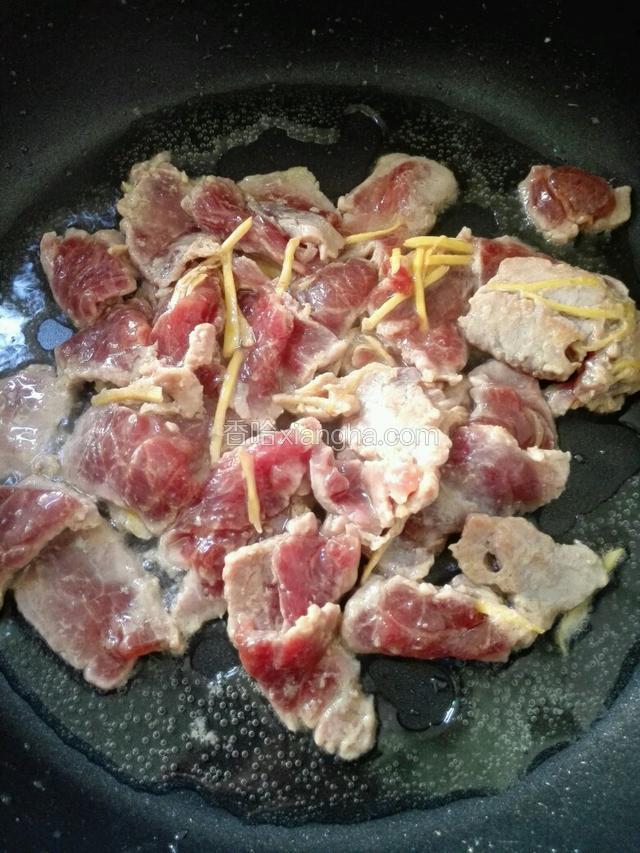 然后把腌好的牛肉放入锅里大火翻炒。