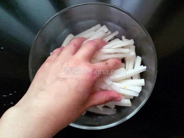 用手抓萝卜条，使萝卜条和盐充分融合。