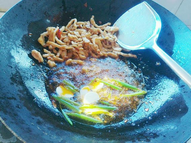 肉丝断生后用锅铲把肉丝推至锅的一端，再放蒜片和少量葱段爆香。（技术不熟练的话，建议还是把肉丝盛在盘子里再继续下一步）