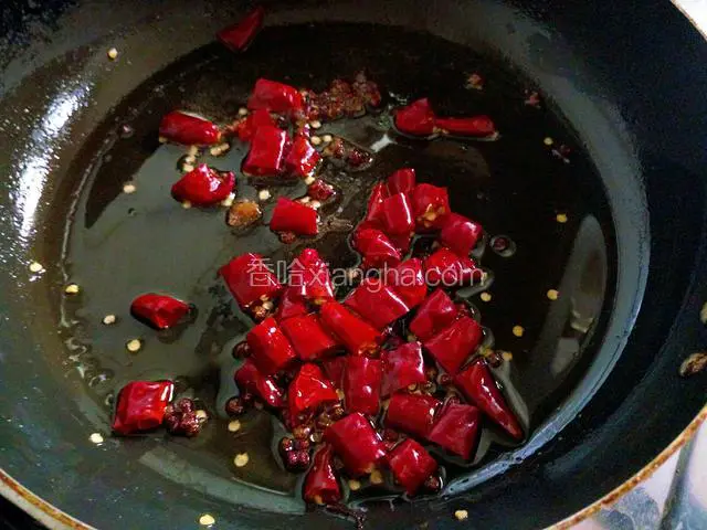锅中留底油，加入花椒粒和干辣椒段，小火煸出香味。