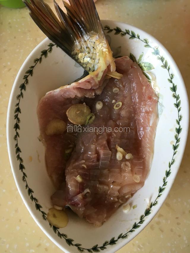 把打完花刀的鱼用盐，料酒和美片，葱段腌制15分钟。