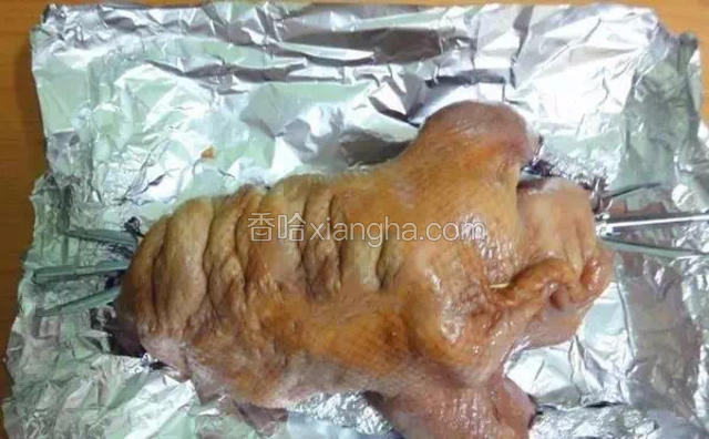 把鸭腿末端和翅尖用锡纸包起来，烤盘也包上锡纸，烤腿用浸湿的棉线扎紧。这时将蜂蜜加白醋，然后用刷子刷遍鸭身，刷的时候要仔细，要把鸭子的各个角度都涂抹到蜂蜜水。蜂蜜加白醋是脆皮水的配方，穿入烧烤架拧紧两端。