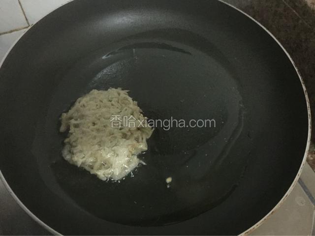 平底锅倒入适量的油烧至六七成热时，用汤匙勺一勺萝卜丝放入锅中压平压实，小火煎至金黄色