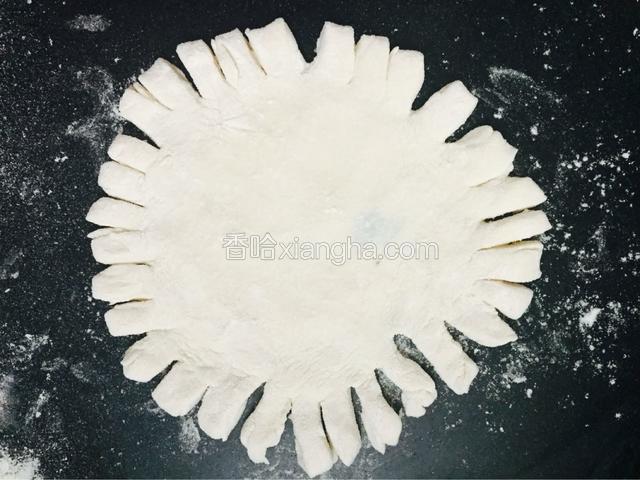 把面皮擀好后，用刀，或者剪刀把周围一圈都剪开或切开至4厘米左右的切口