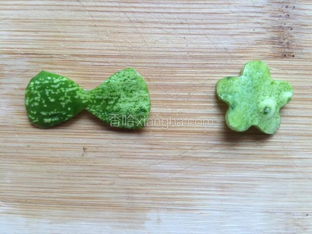 切三片火腿肠，黄瓜取皮用模具各印出小花，再切个蝴蝶结。火腿肠忘拍照了