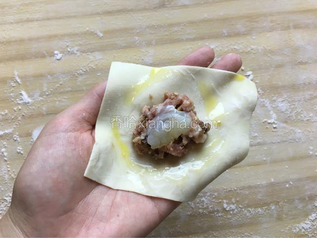 放入适量的肉馅，再在肉馅里加入虾仁，周围涂适量的蛋液然后包起来！重复此动作直至包完。