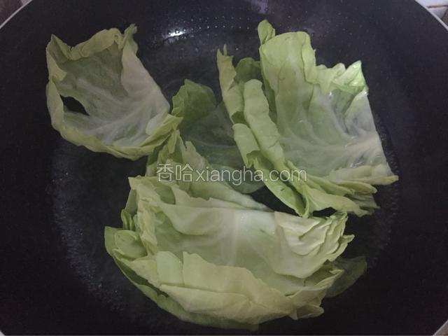 锅中放入适量清水烧开后放入油和盐，再放入卷心菜焯熟变软后捞出
