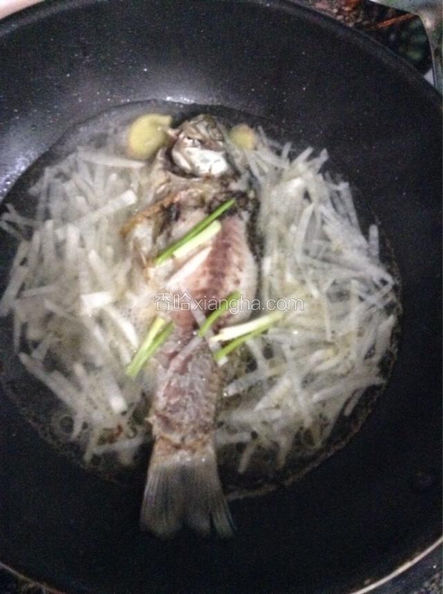 煎好后下料酒葱姜，注入清水，再下萝卜丝，大火烧开转小火慢炖十分钟。