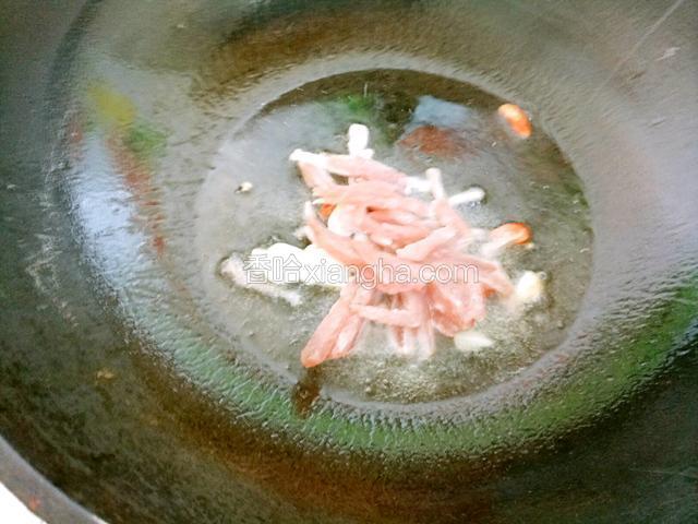 锅中烧油下葱姜蒜爆香，下肉丝翻炒均匀。