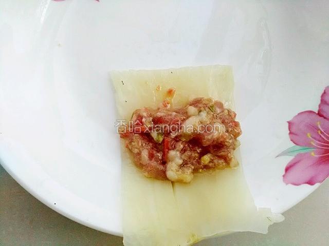 取一个白菜帮，把肉馅放在菜帮上