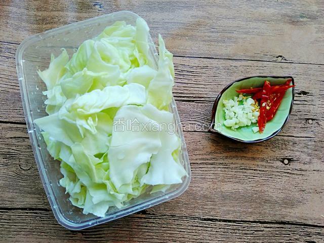 包菜用手撕出，清洗干净用盐水浸泡后撕成小片。干辣椒切丝，蒜瓣切蒜末。