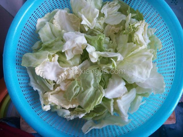 卷心菜用淡盐水浸泡20分钟，再用流水一片片洗净，撒成大小块。晾水备用