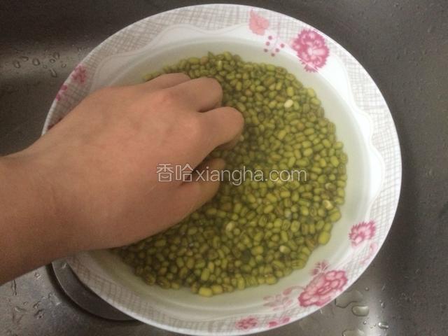 用手轻轻抓绿豆，进一步清洗绿豆