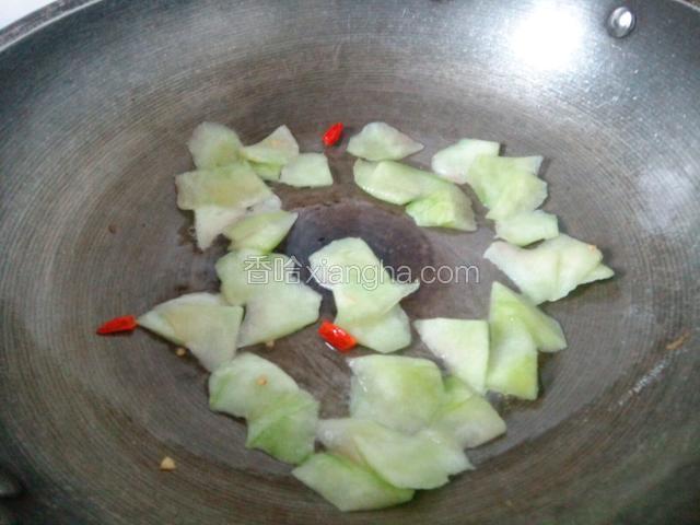锅油热，爆香朝天椒，倒入瓜皮翻炒