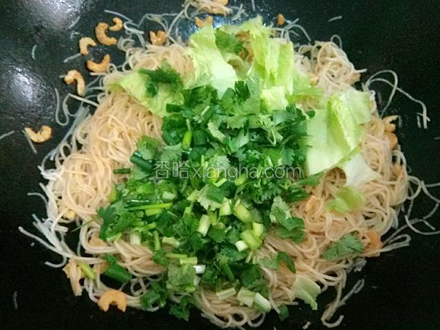 接着倒入生菜茎干和香葱芫茜，快速翻炒均匀。