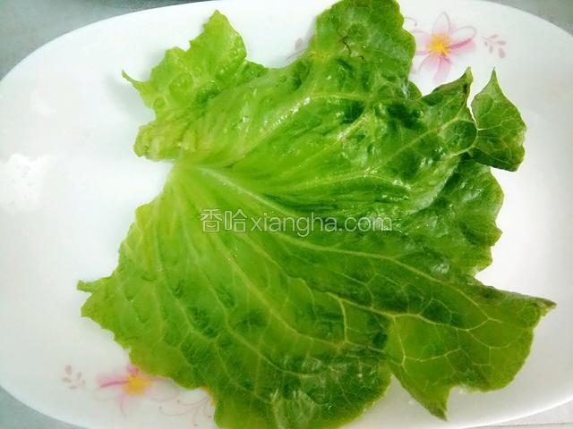 在碟子上铺上一块生菜叶。