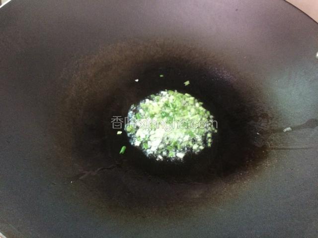 锅里倒入适量的油，烧热后调成中火，放入葱白爆香。