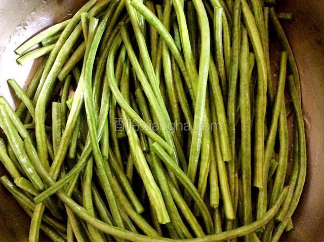 豇豆除去两头部位，一根豇豆用手折断成三小段，用水清洗干净控干水份