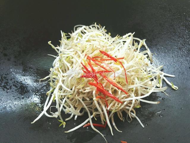 倒入绿豆芽和红尖椒改大火翻炒，洒适量清水，调入适量盐、鸡精、生抽、醋和少许白糖炒至绿豆芽软化