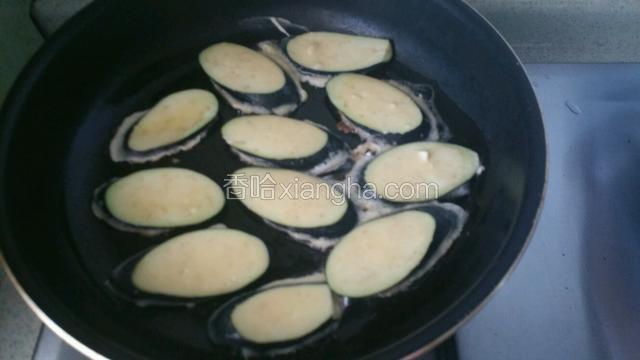 平底锅中加入适量油，茄子片均匀沾上面糊放入锅中