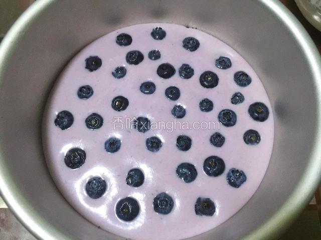 先往模具中倒入一部分慕斯糊，然后铺一层蓝莓。