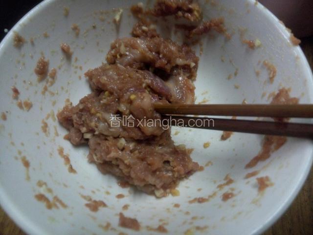 再肉里加入切碎的蒜沫与姜沫，用筷子朝着一个方向搅打，使肉上筋