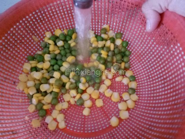 将玉米粒和豆粒从冰箱冷冻室取出，用冷水冲洗至冰融化。