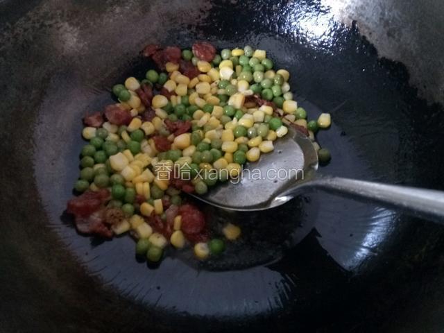 接着放入玉米粒和豆粒翻炒均匀。