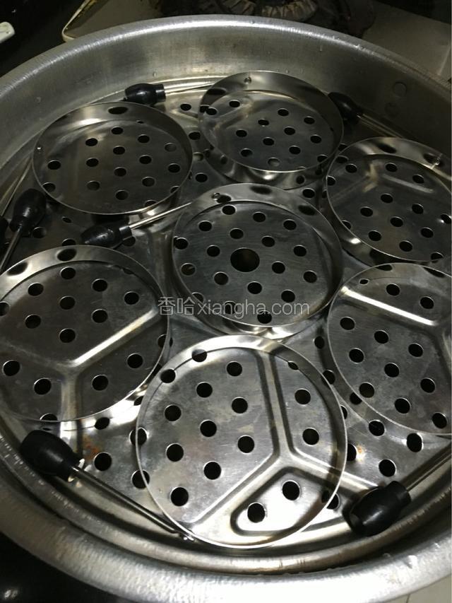 蒸鼓格子上面挨着放上煎蛋定型的圆，铺上蒸东西专用布，用手把布弄凹下去。