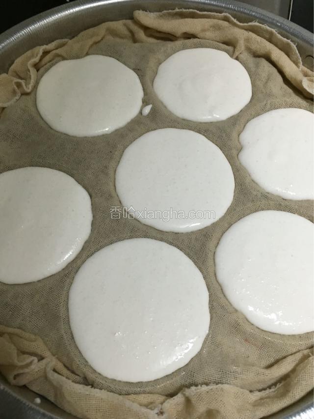 用勺子，从中间的格子开始，导入米浆，不要太满了，因为蒸了会涨起来。