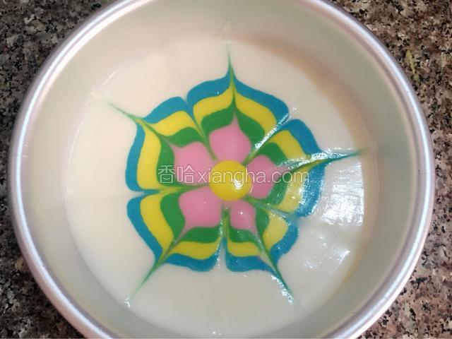 绿色慕斯糊和粉色慕斯糊轻轻镇动使其扩散，用牙签在慕斯糊中间位置向边缘均匀的画出五条直线，再从两条线的中间从慕斯糊边缘向中间画五条直线，一朵可爱的彩色花朵就形成了，滴入黄色的慕斯糊入冰箱冷藏四小时。                                                                               
