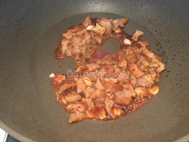 将肉丁放入酱汁中，快速拌匀。