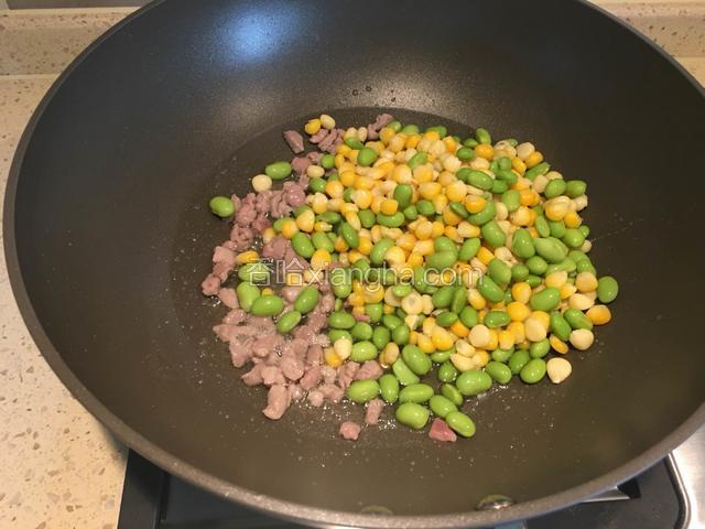 肉丁炒变色时，放入玉米粒和毛豆粒，翻炒均匀，即可关火。