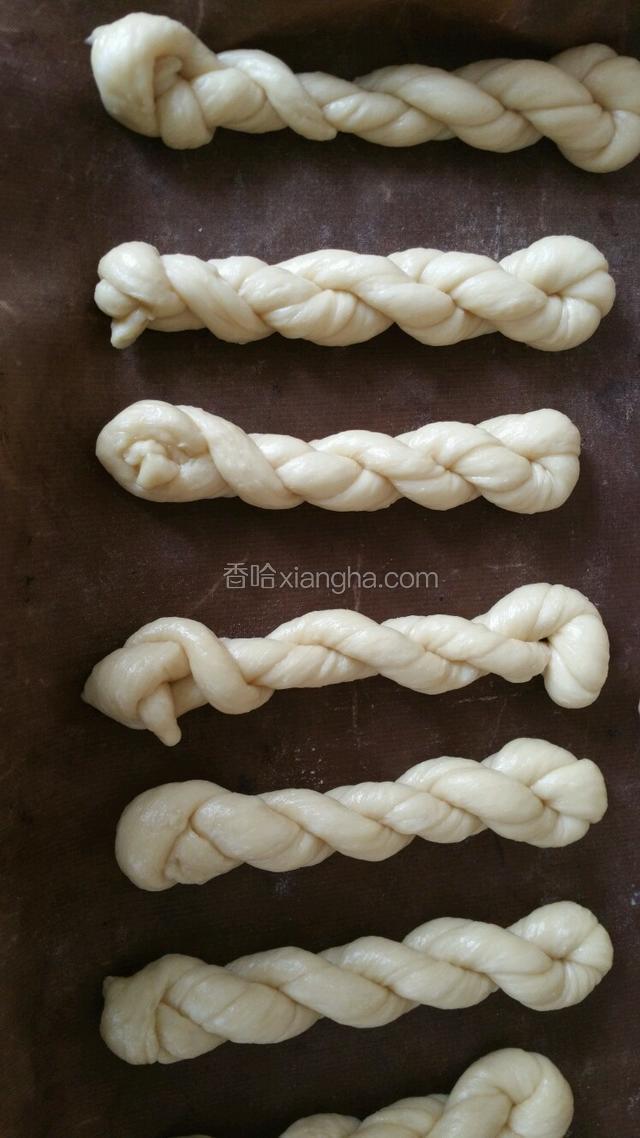 搓上劲后，抓住二端自然卷在一起，一头从中间手指处穿过即可，码放在烤盘中留些空隙