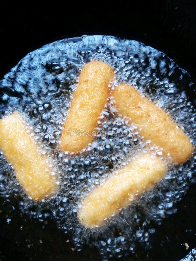 油烧七成热，下油锅炸马铃薯泥棒，炸成金黄色捞出，用竹签一头串上韭菜，一头串上马铃薯