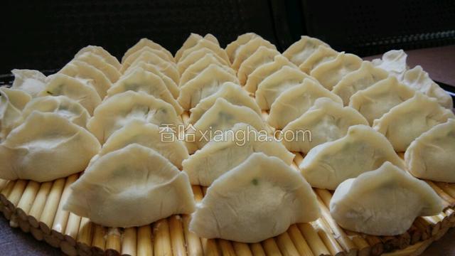 将中间捏紧，左右两个虎口处卡住饺子两端，大拇指用点力捏紧饺子边边，饺子就包好了