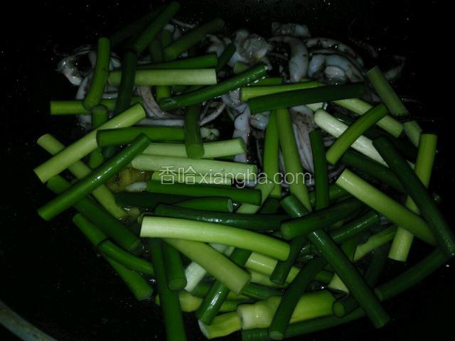 然后放入鱿鱼须，跟蒜苔入锅翻炒，加耗油一汤匙，一点点盐
