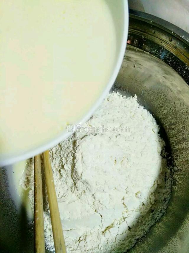 把拌匀的牛奶倒入面粉中。