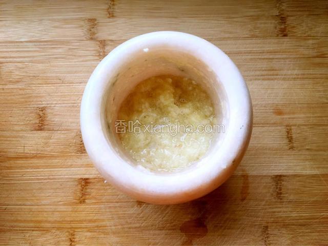 把蒜砸成蒜泥，稍加一点水稀释一下。