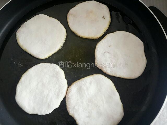 平底锅放少许食用油，把饼放进锅里。