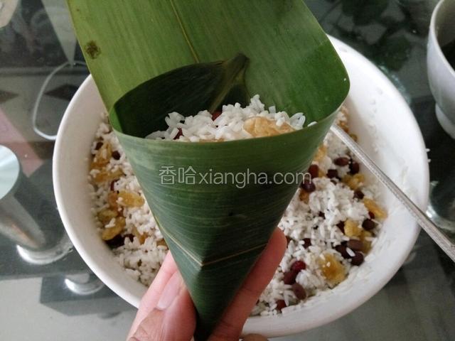 粽叶折成漏斗状，但尖端不能有缝隙，以防漏米