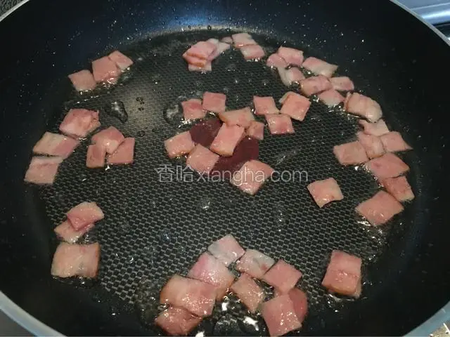 培根切成正方形块，平底锅倒入适量的油煎熟备用！